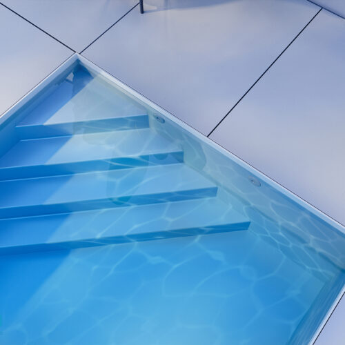 Wizualizacje 3D baseny. Fotorealistyczny render basenu ogrodowego z widokiem na schody basenowe. 3d visualizations swimming pools, Photorealistic render of a backyard swimming pool with a view of the pool steps..